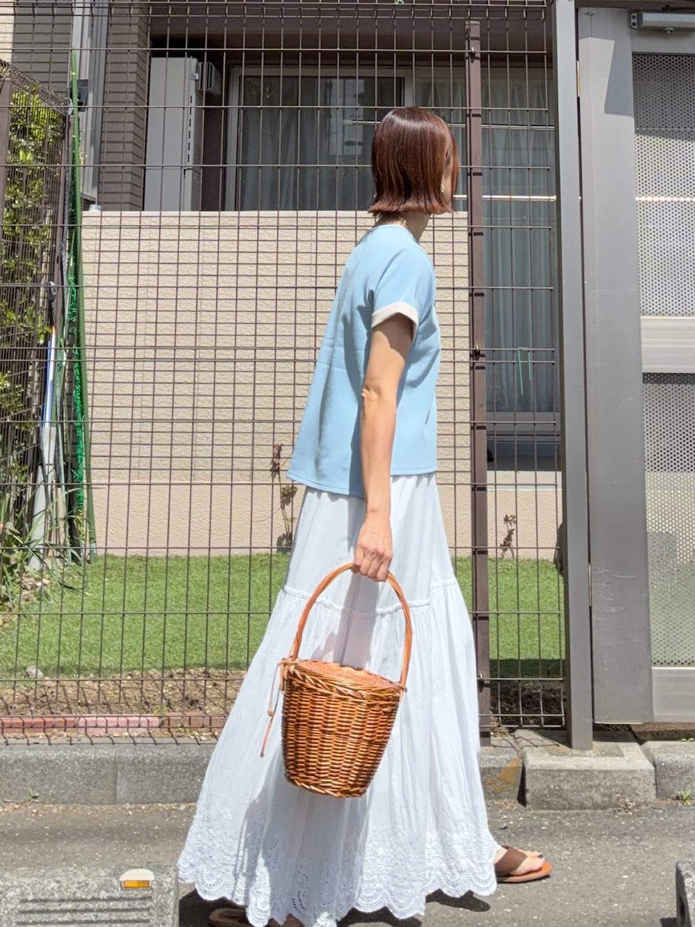ホワイト系のスカート、ブルー系のTシャツ/カットソーを着用したレディースの春コーディネートの2枚目の写真