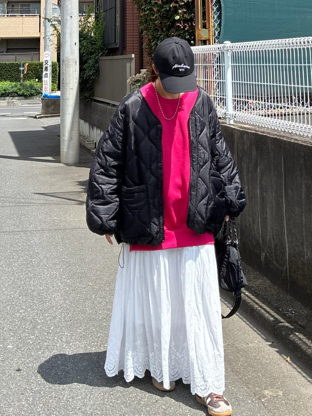 ブラック系のトートバッグ、ブラック系のブルゾン、ブラック系のキャップを着用したレディースの夏コーディネートの4枚目の写真