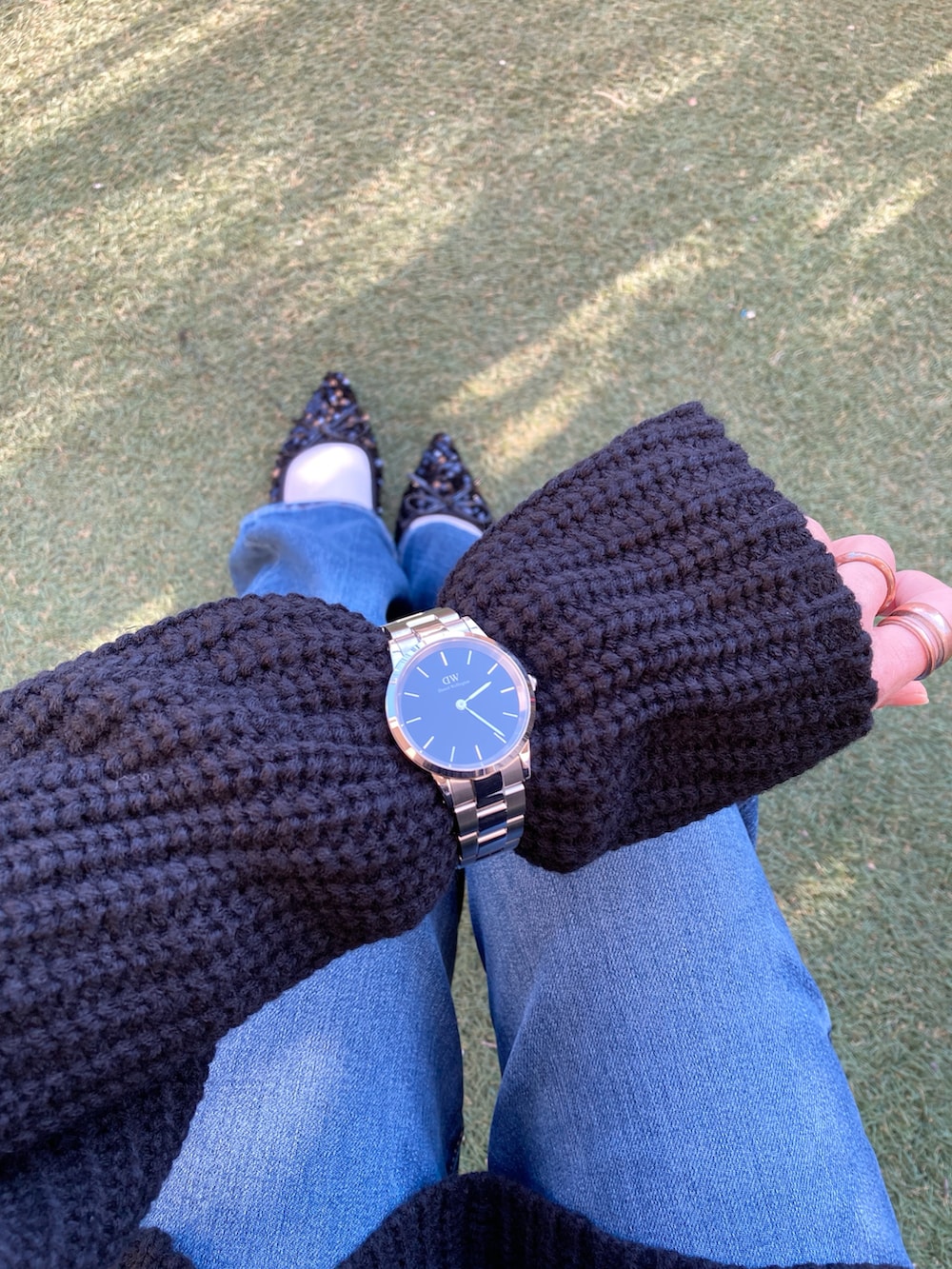 ブラック系のニット/セーター、ブルー系のデニムパンツ、ブラック系のショルダーバッグを着用したレディースの冬コーディネートの4枚目の写真