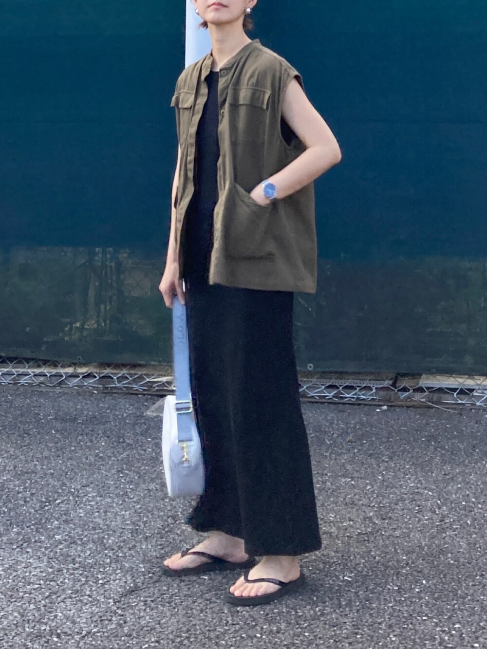 グリーン系のベスト、ブラック系のワンピース、ホワイト系のショルダーバッグを着用したレディースの夏コーディネートの4枚目の写真