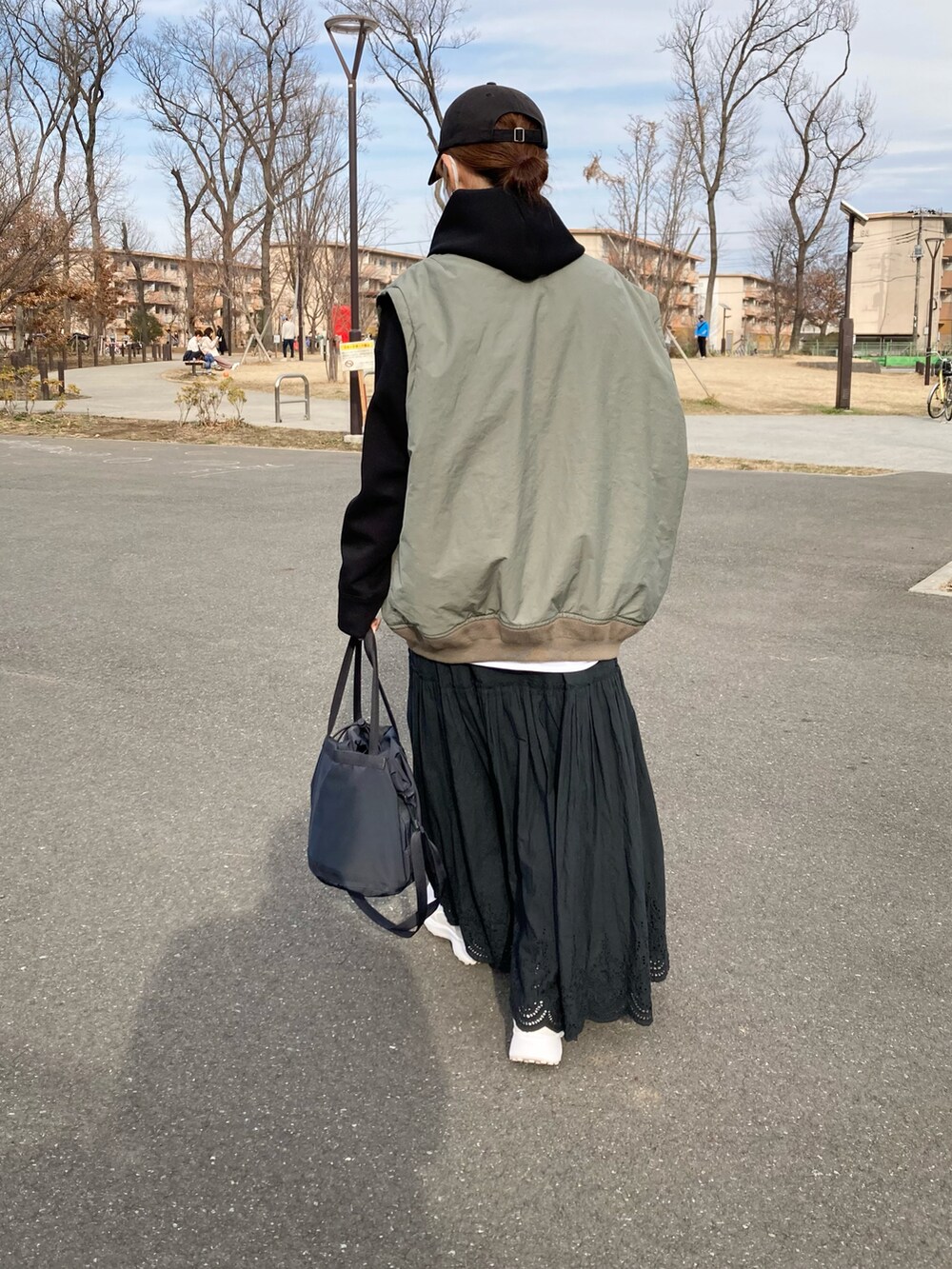グリーン系のMA-1、ブラック系のパーカー、ブラック系のスカートを着用したレディースの春コーディネートの5枚目の写真