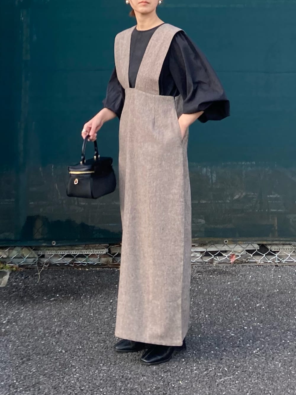 ブラック系のシャツ/ブラウス、ブラウン系のジャンパースカートを着用したレディースの冬コーディネートの2枚目の写真