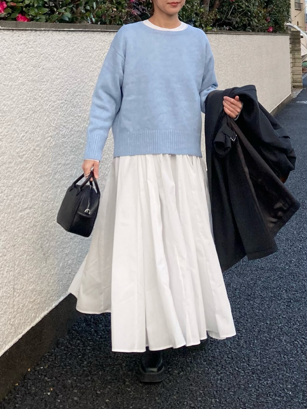 ブルー系のニット/セーター、ホワイト系のシャツワンピース、ブラック系のボストンバッグを着用したレディースの冬コーディネートの5枚目の写真