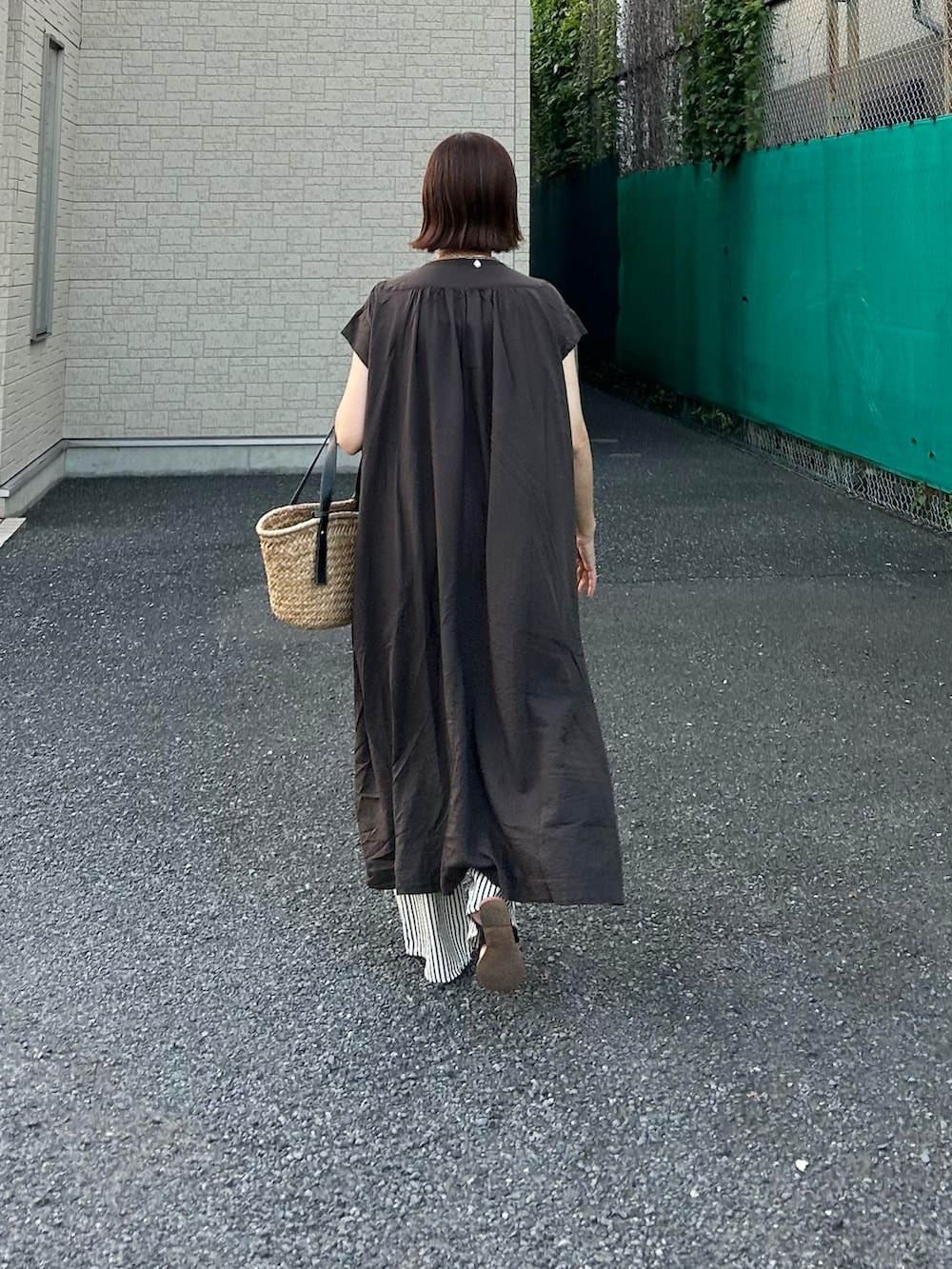 グレー系のワンピース、ブラック系のかごバッグ、ブルー系のその他パンツを着用したレディースの夏コーディネートの3枚目の写真