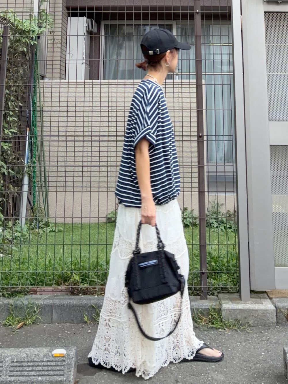 ブルー系のTシャツ/カットソー、ホワイト系のスカート、ブラック系のトートバッグを着用したレディースの秋コーディネートの2枚目の写真