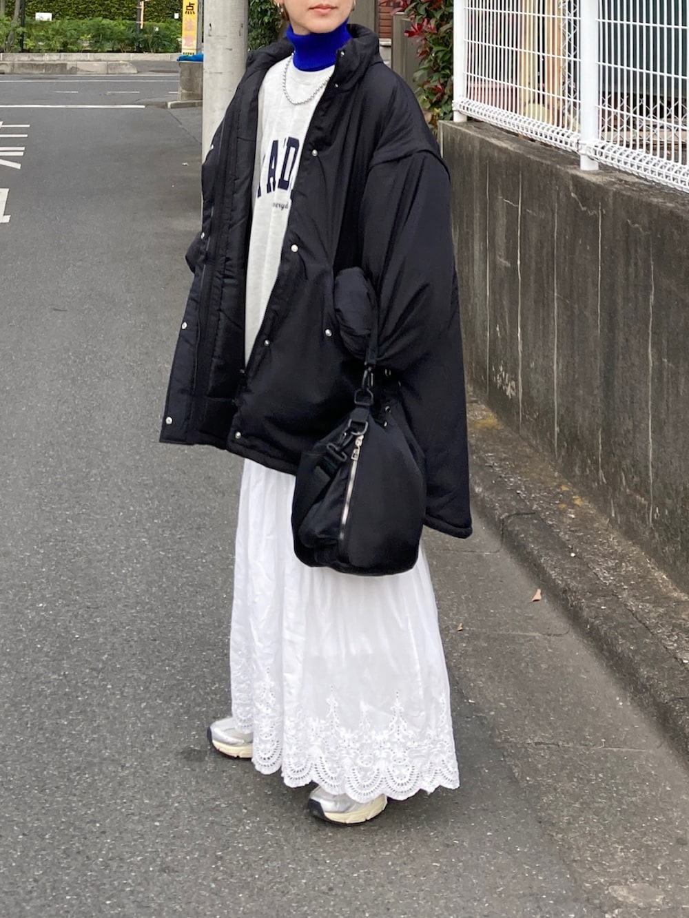 ブラック系のダウンジャケット/コート、ホワイト系のスウェット、ホワイト系のスカートを着用したレディースの秋コーディネートの3枚目の写真