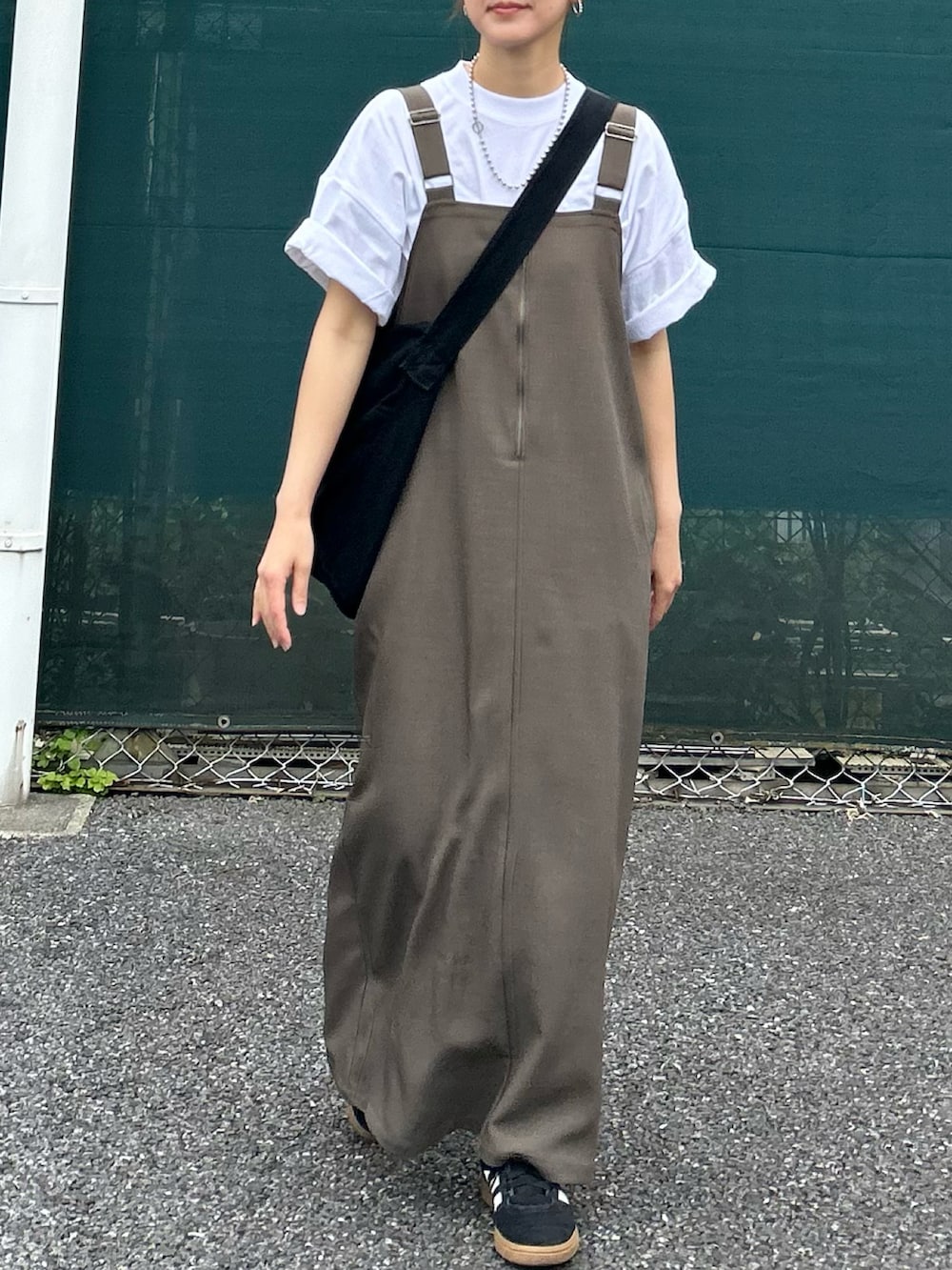 ベージュ系のワンピース、ホワイト系のTシャツ/カットソー、ブラック系のショルダーバッグを着用したレディースの春コーディネートの3枚目の写真