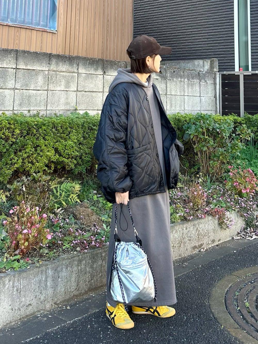 ブラック系のブルゾン、グレー系のワンピース、シルバー系のトートバッグを着用したレディースの冬コーディネートの3枚目の写真