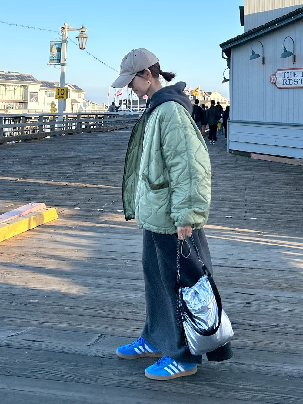 グリーン系のノーカラージャケット、グレー系のワンピース、シルバー系のトートバッグを着用したレディースの冬コーディネートの2枚目の写真