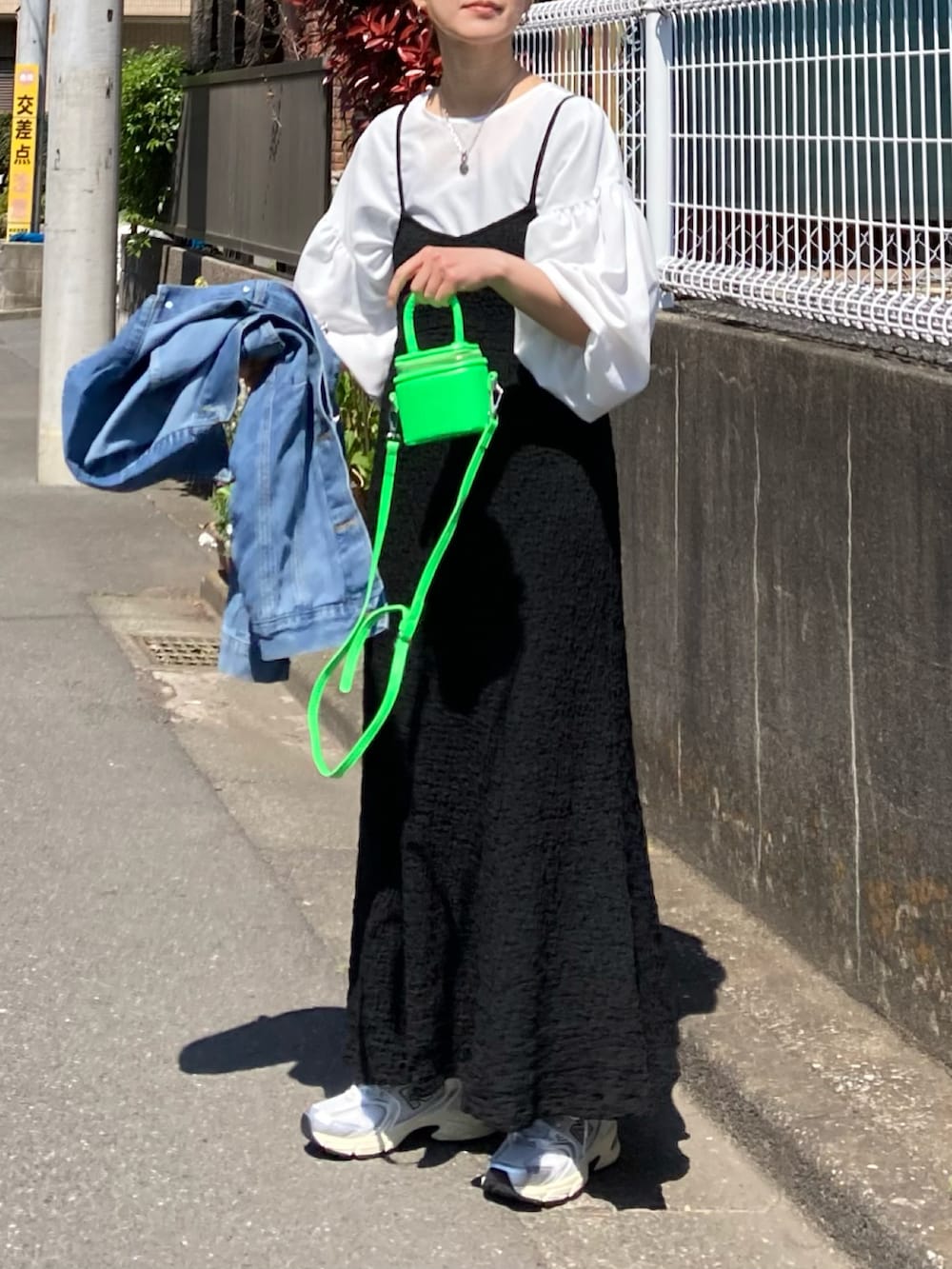 ブラック系のワンピース、ホワイト系のシャツ/ブラウス、グリーン系のショルダーバッグを着用したレディースの春コーディネートの3枚目の写真