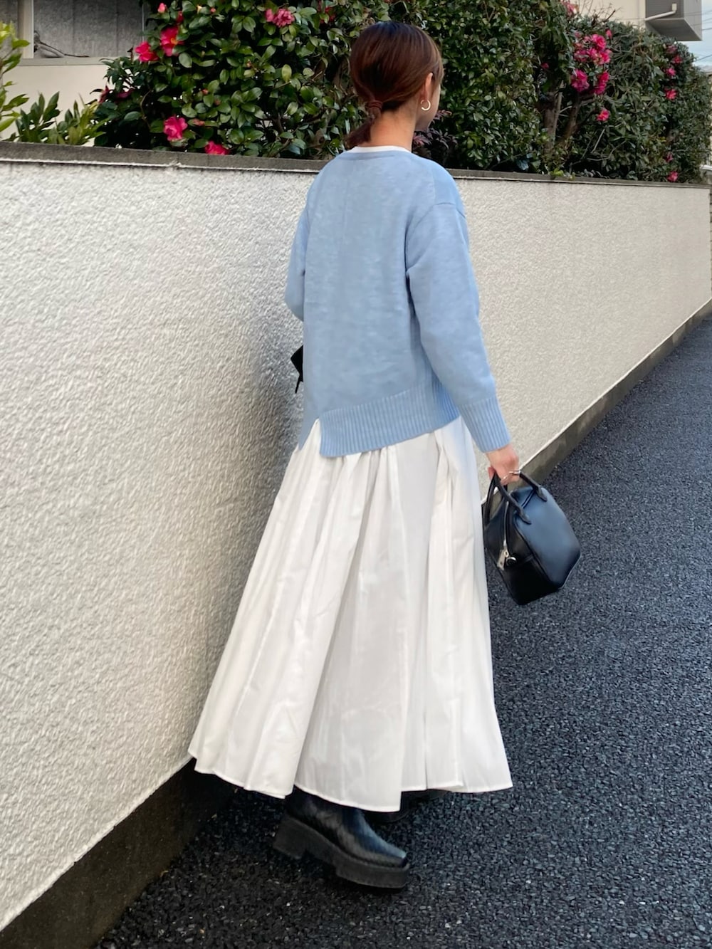 ブルー系のニット/セーター、ホワイト系のシャツワンピース、ブラック系のボストンバッグを着用したレディースの冬コーディネートの2枚目の写真