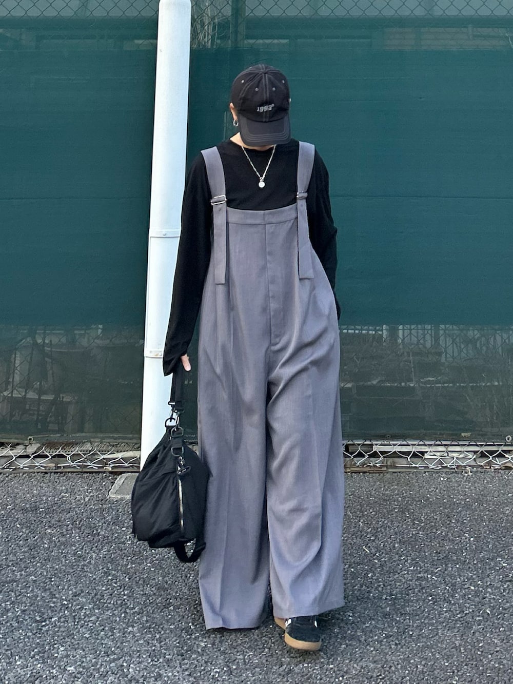 グレー系のサロペット/オーバーオール、ブラック系のショルダーバッグ、ブラック系のキャップを着用したレディースの春コーディネートの3枚目の写真