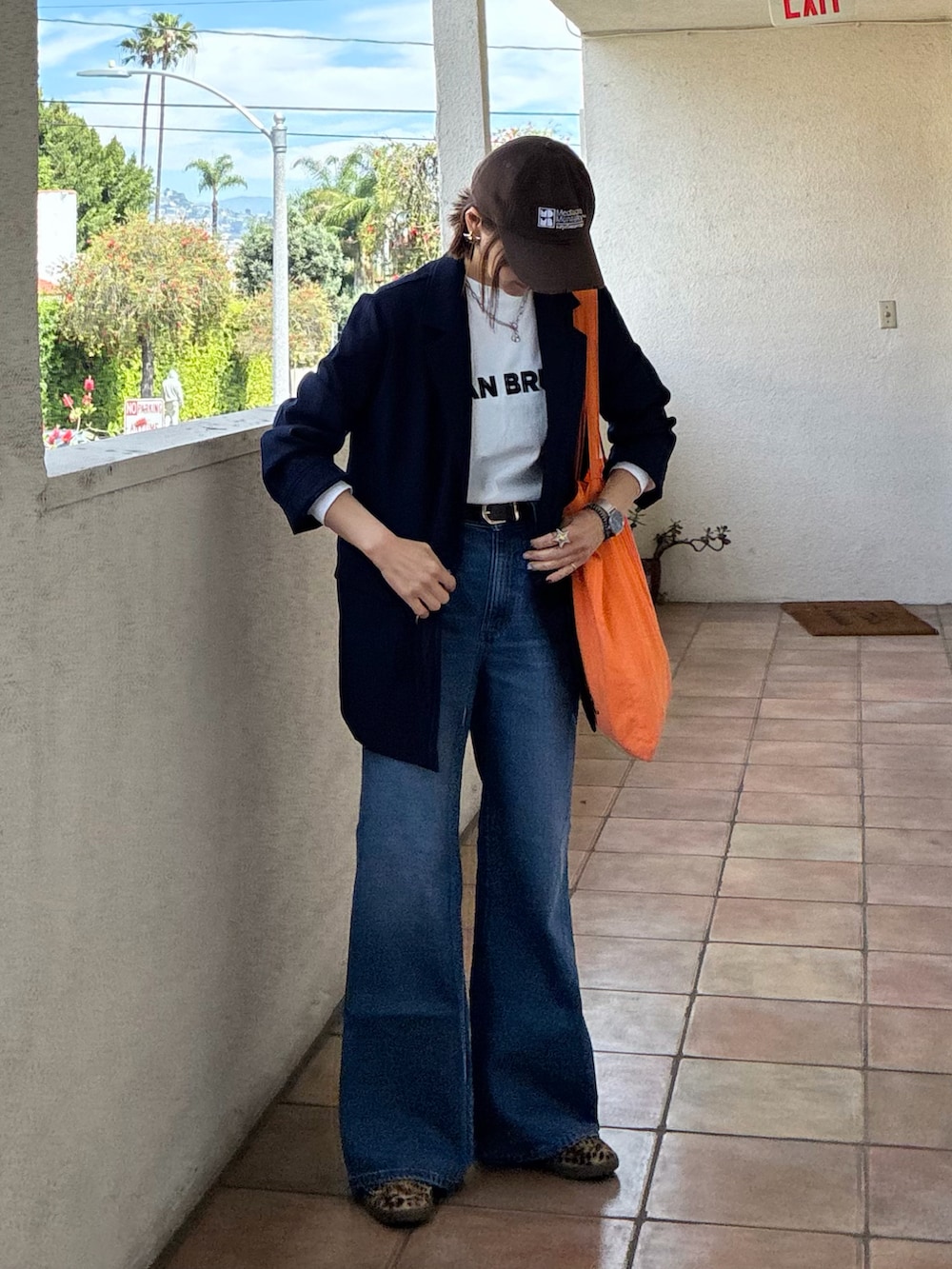 ブルー系のテーラードジャケット、ホワイト系のTシャツ/カットソー、ブラック系のスニーカーを着用したレディースの春コーディネートの4枚目の写真