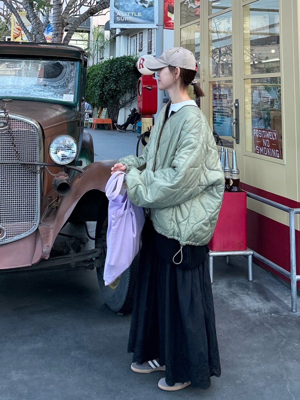 グリーン系のノーカラージャケット、ブラック系のニット/セーター、ブラック系のスカートを着用したレディースの冬コーディネートの3枚目の写真