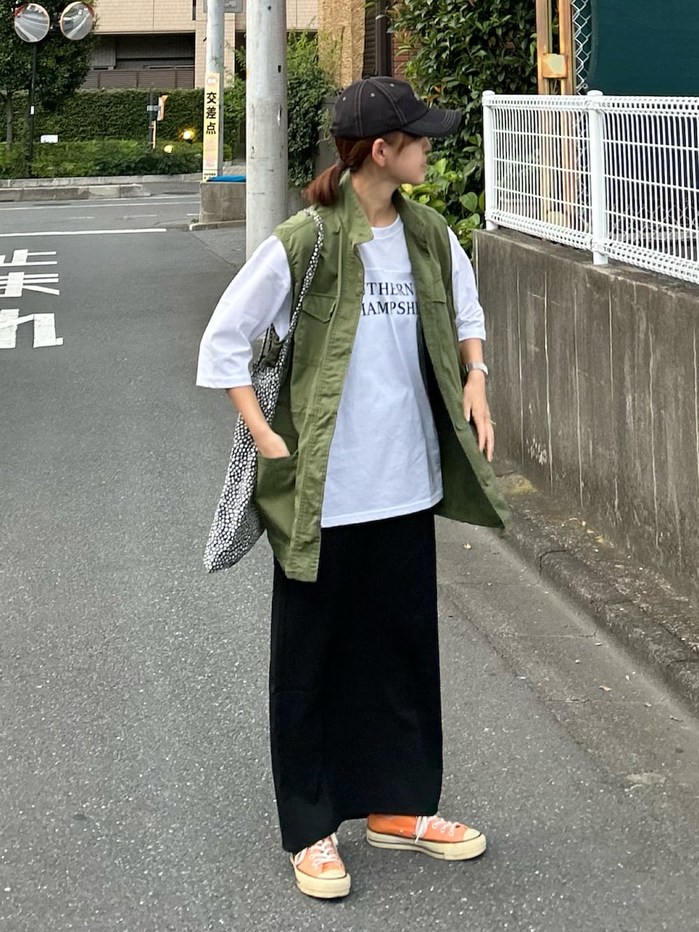 ホワイト系のTシャツ/カットソー、グリーン系のベスト、ブラック系のスカートを着用したレディースの夏コーディネートの3枚目の写真