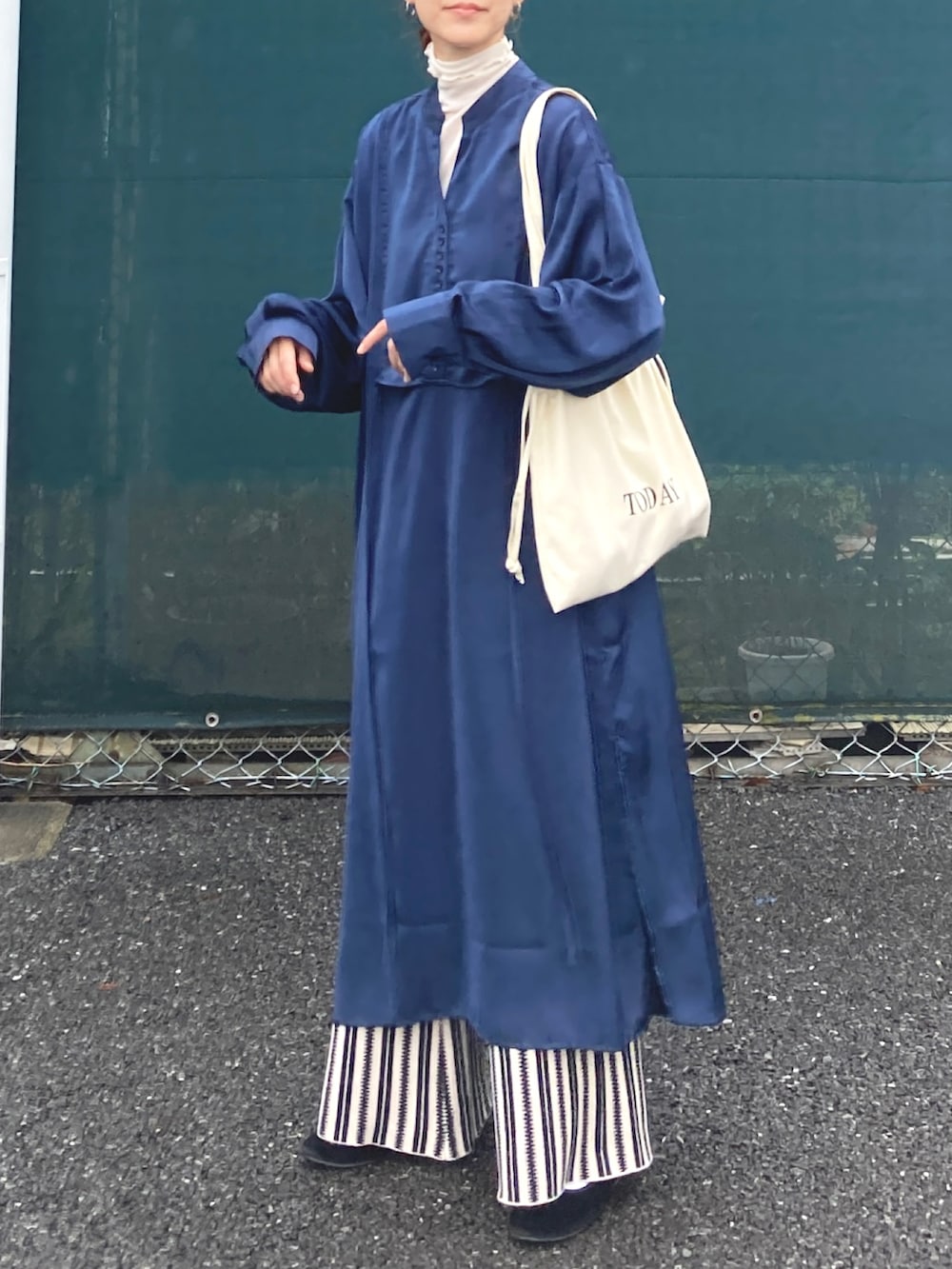 ブルー系のシャツワンピース、ブラック系のその他パンツ、ホワイト系のトートバッグを着用したレディースの秋コーディネートの5枚目の写真