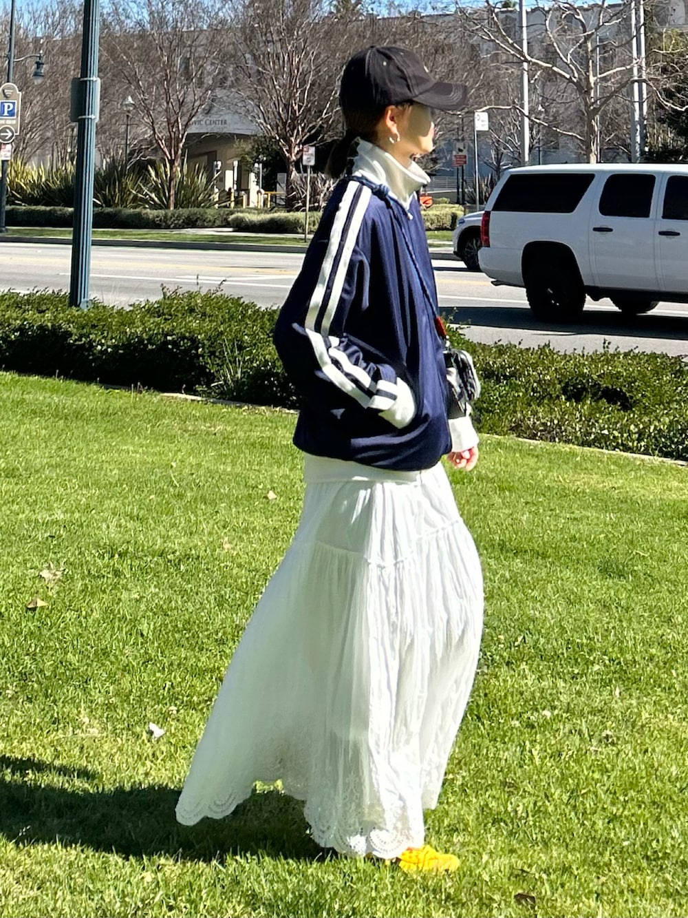 ブルー系のジャージ、ホワイト系のスカート、グレー系のショルダーバッグを着用したレディースの冬コーディネートの3枚目の写真