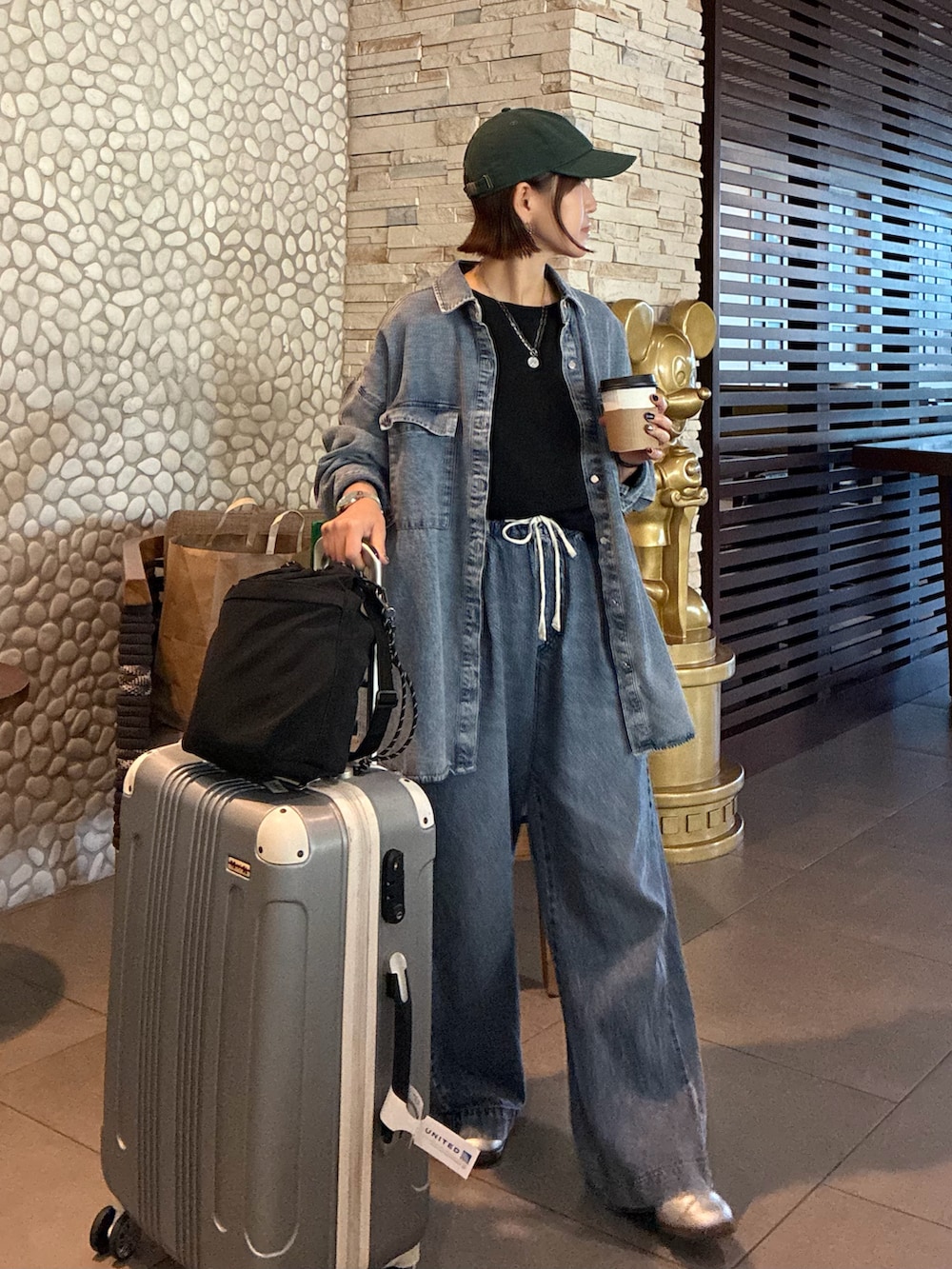 ブルー系のシャツ/ブラウス、ブラック系のショルダーバッグ、ブラック系のTシャツ/カットソーを着用したレディースの春コーディネートの4枚目の写真