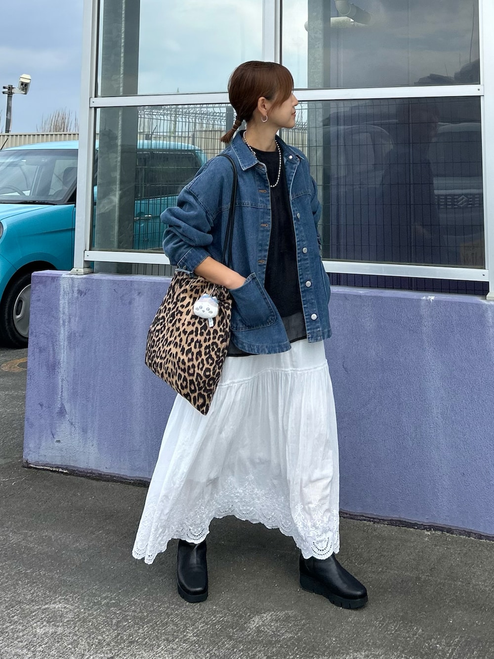 ホワイト系のスカート、ブルー系のデニムジャケット、ブラウン系のトートバッグを着用したレディースの秋コーディネートの3枚目の写真