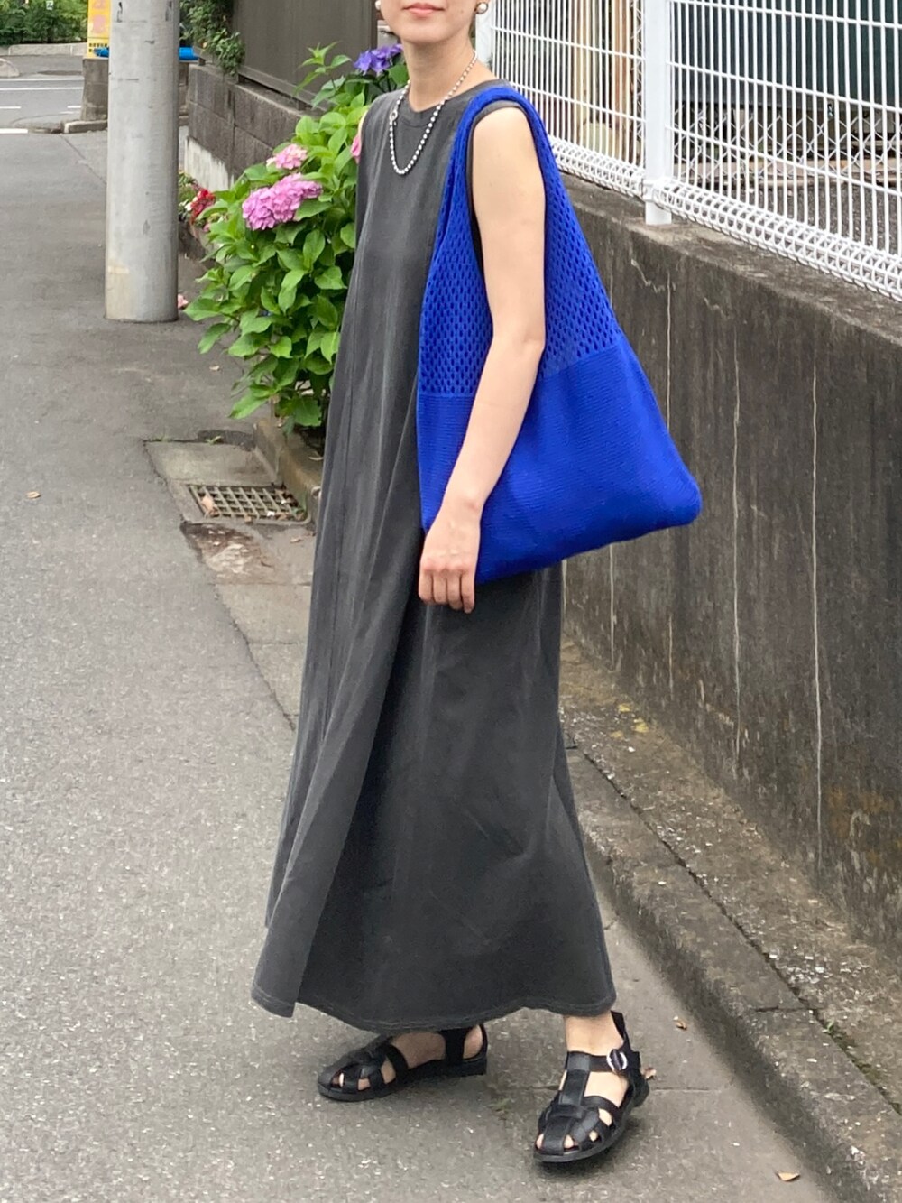グレー系のワンピース、ブルー系のショルダーバッグ、ブラック系のサンダルを着用したレディースの夏コーディネートの3枚目の写真