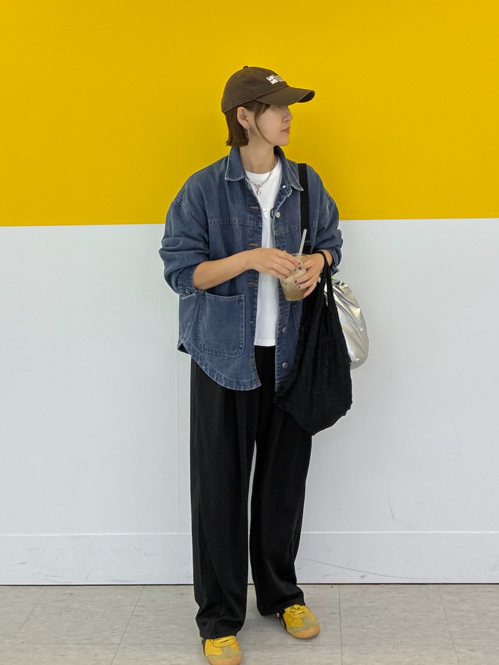 ブラック系のスラックス、ブルー系のデニムジャケット、ホワイト系のTシャツ/カットソーを着用したレディースの春コーディネートの2枚目の写真
