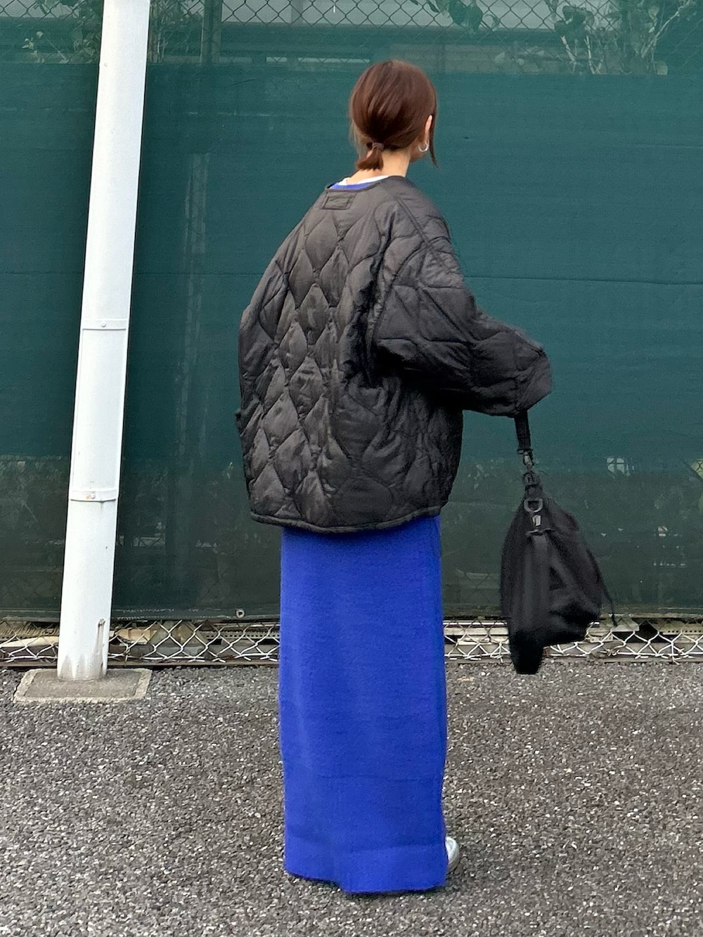 ブラック系のノーカラージャケット、ブルー系のワンピース、シルバー系のスニーカーを着用したレディースの秋コーディネートの4枚目の写真