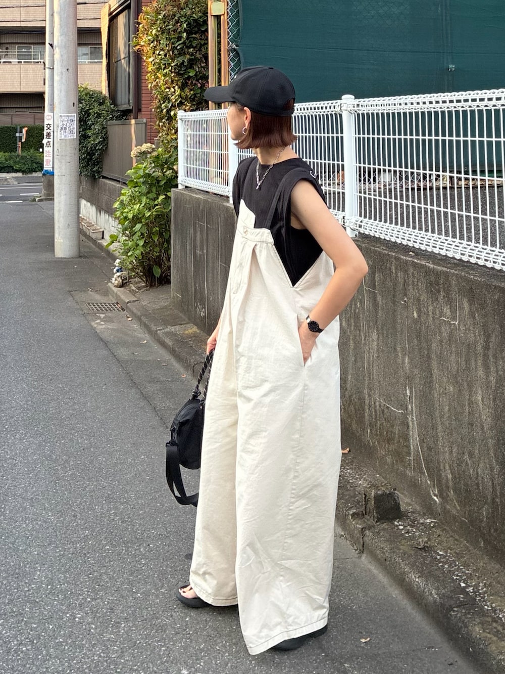 ホワイト系のサロペット/オーバーオール、ブラック系のTシャツ/カットソー、ブラック系のトートバッグを着用したレディースの夏コーディネートの2枚目の写真