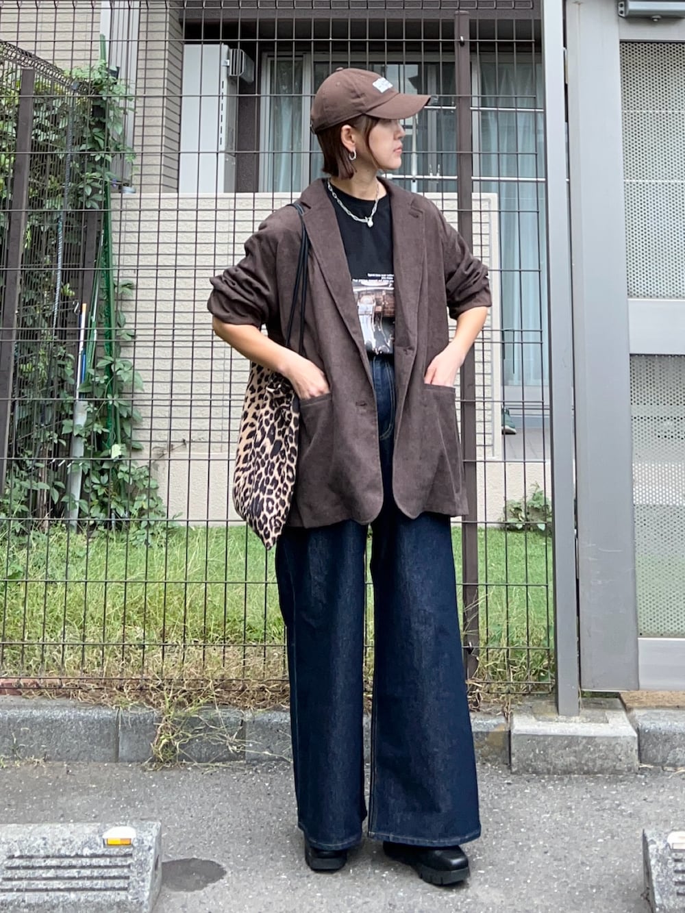 ブラック系のTシャツ/カットソー、ブラウン系のテーラードジャケット、ブルー系のデニムパンツを着用したレディースの秋コーディネートの5枚目の写真