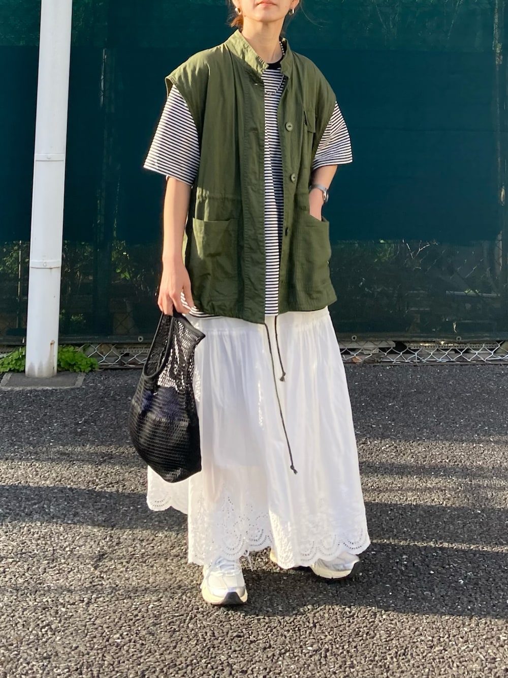 ブラック系のTシャツ/カットソー、ブルー系のデニムジャケット、ホワイト系のスカートを着用したレディースの春コーディネートの5枚目の写真