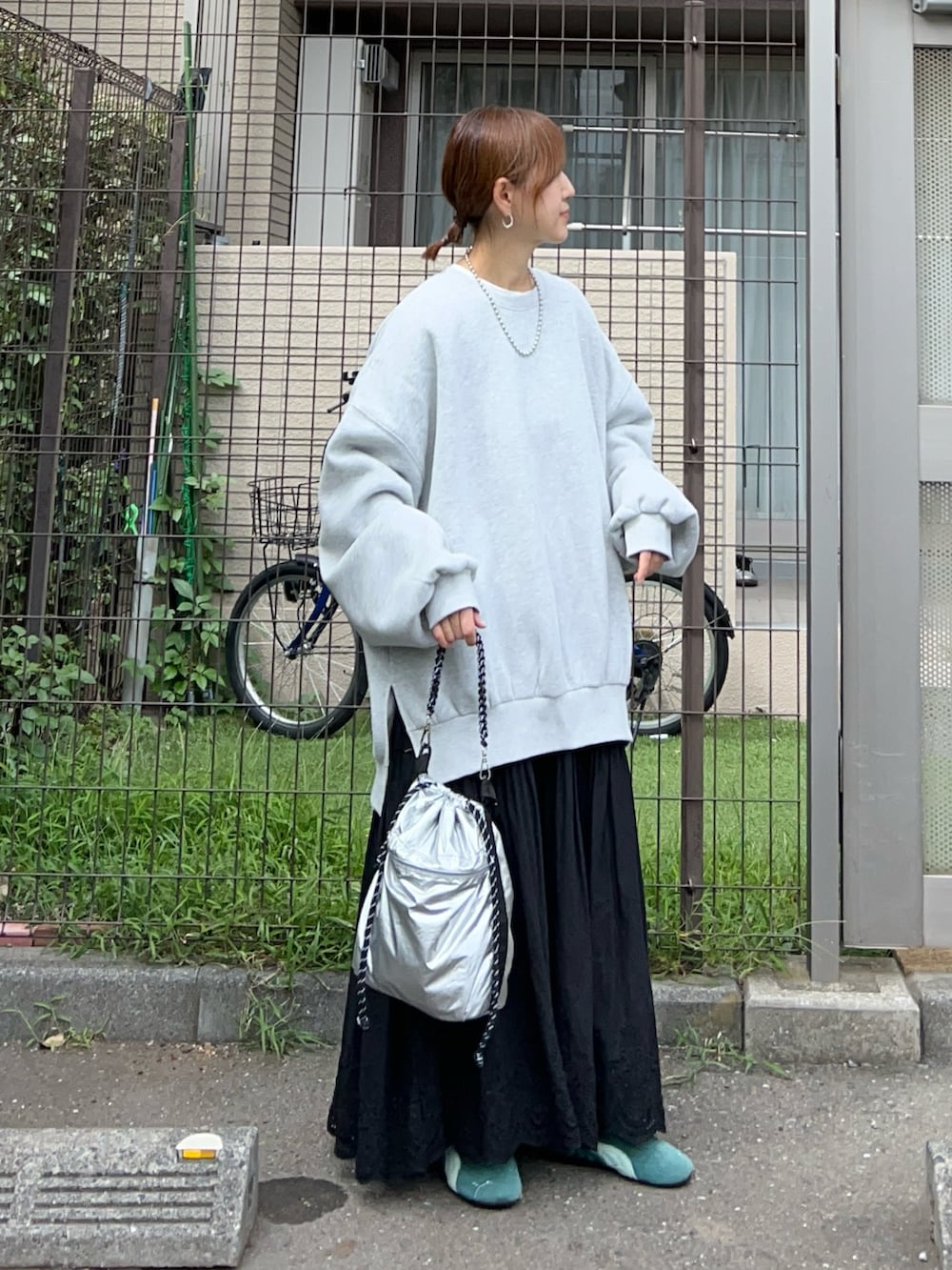 グレー系のスウェット、シルバー系のトートバッグ、ブラック系のスカートを着用したレディースの冬コーディネートの3枚目の写真