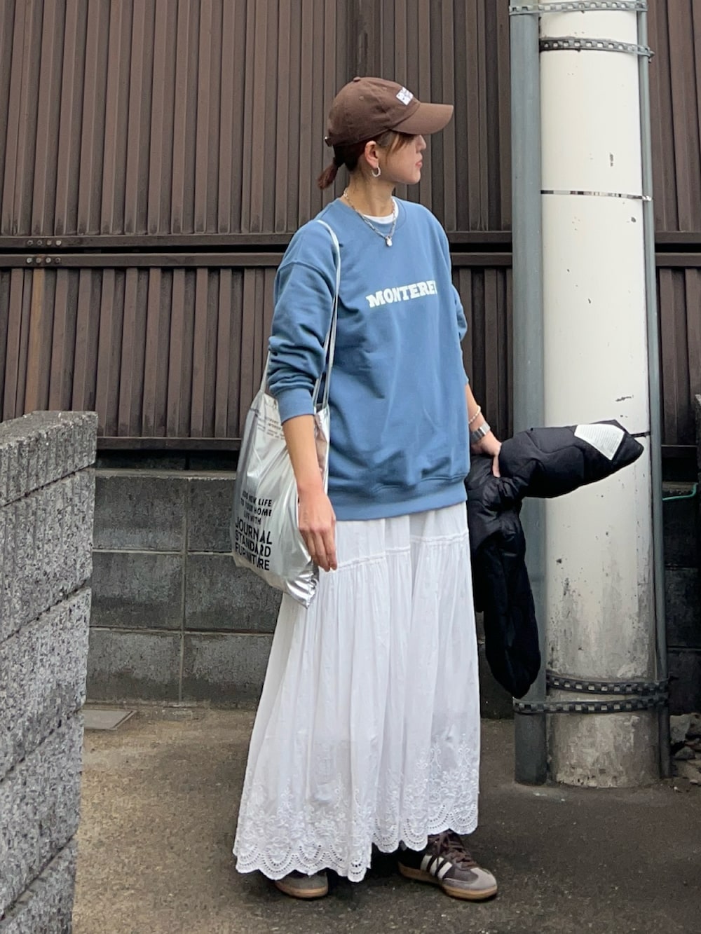 ブルー系のスウェット、ホワイト系のスカート、ブラック系のブルゾンを着用したレディースの冬コーディネートの3枚目の写真