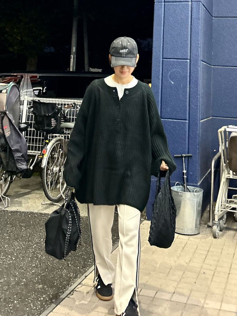 ブラック系のニット/セーター、ベージュ系のスウェットパンツ、ブラック系のトートバッグを着用したレディースの秋コーディネートの4枚目の写真