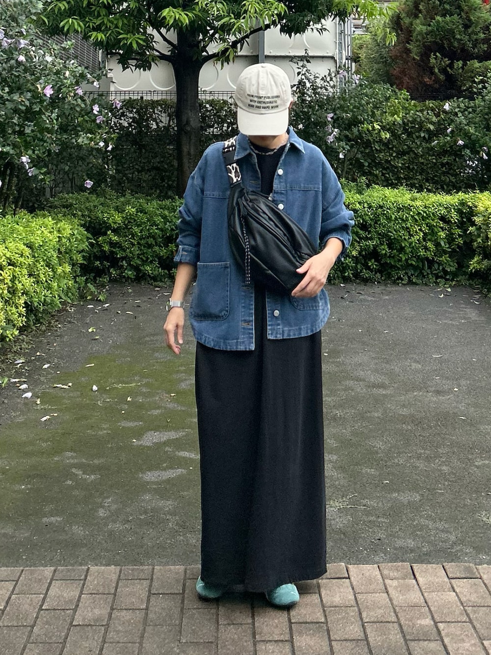 ブラック系のボディバッグ/ウエストポーチ、グリーン系のスニーカー、ブルー系のデニムジャケットを着用したレディースの秋コーディネートの3枚目の写真