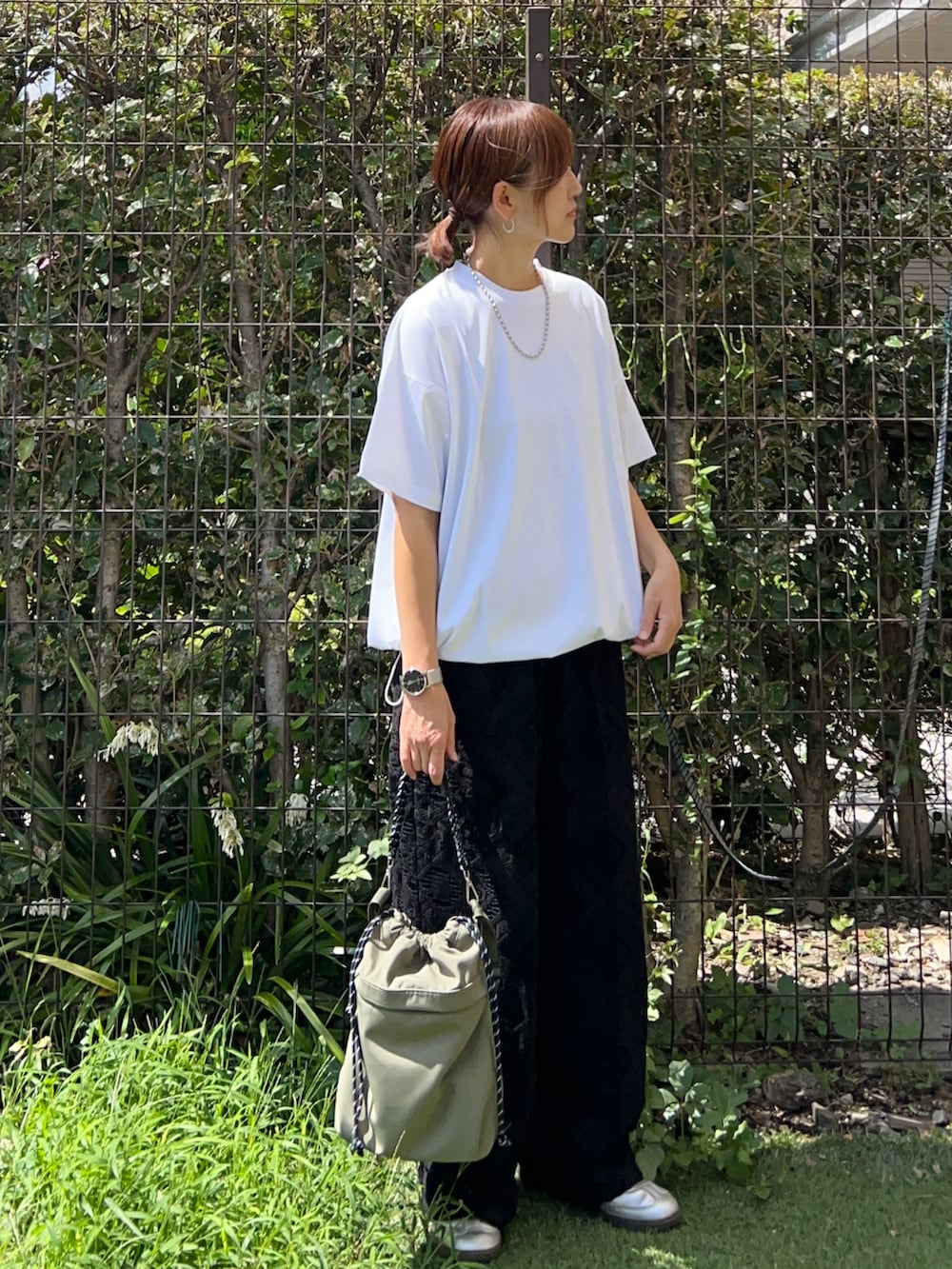 グレー系のTシャツ/カットソー、ブラック系のその他パンツ、グリーン系のトートバッグを着用したレディースの秋コーディネートの2枚目の写真