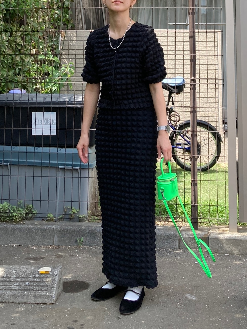 ブラック系のカーディガン/ボレロ、ブラック系のスカート、グリーン系のショルダーバッグを着用したレディースの夏コーディネートの3枚目の写真