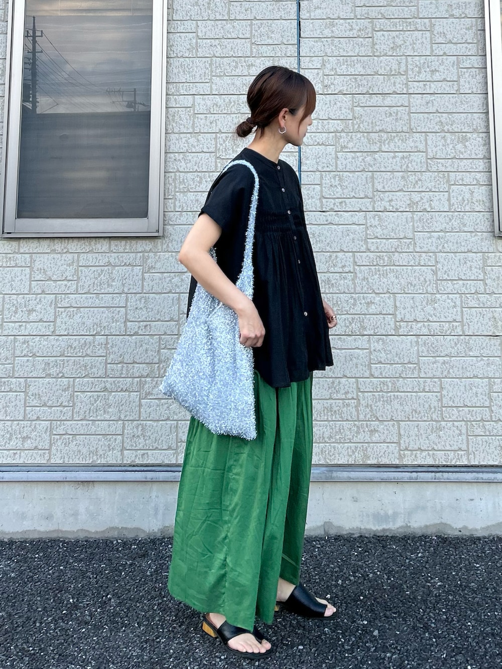 ブラック系のシャツ/ブラウス、グリーン系のスカート、シルバー系のトートバッグを着用したレディースの夏コーディネートの2枚目の写真