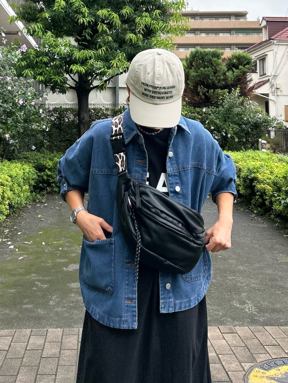 ブラック系のボディバッグ/ウエストポーチ、グリーン系のスニーカー、ブルー系のデニムジャケットを着用したレディースの秋コーディネートの4枚目の写真