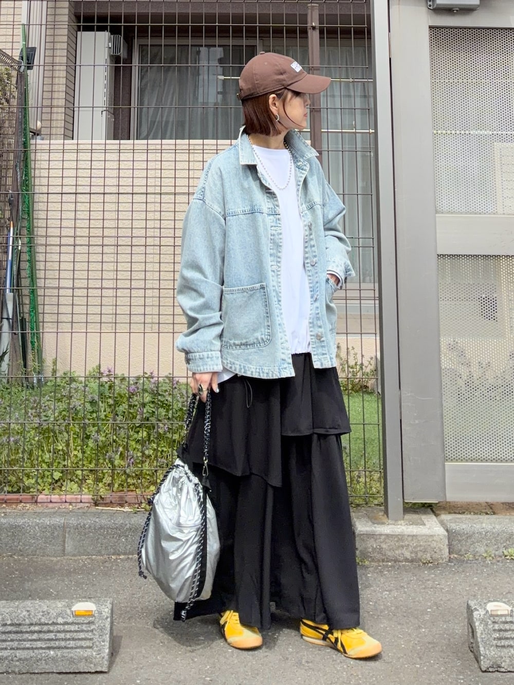 ホワイト系のTシャツ/カットソー、ブルー系のデニムジャケット、ブラック系のスカートを着用したレディースの春コーディネートの3枚目の写真