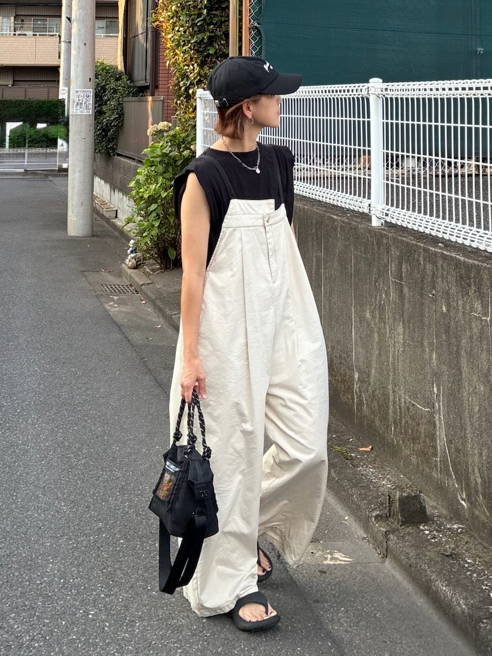 ホワイト系のサロペット/オーバーオール、ブラック系のTシャツ/カットソー、ブラック系のトートバッグを着用したレディースの夏コーディネートの4枚目の写真
