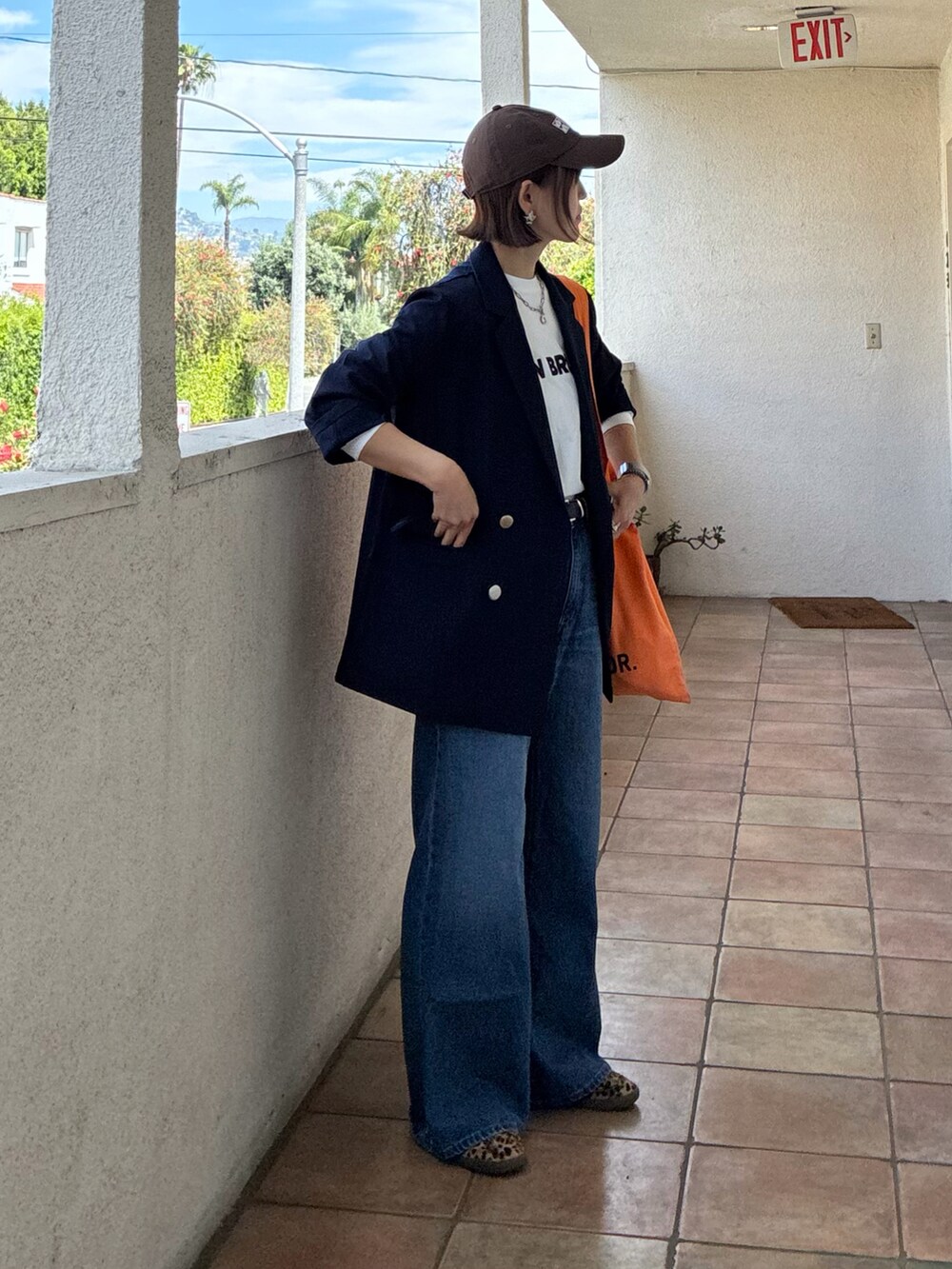 ブルー系のテーラードジャケット、ホワイト系のTシャツ/カットソー、ブラック系のスニーカーを着用したレディースの春コーディネートの2枚目の写真