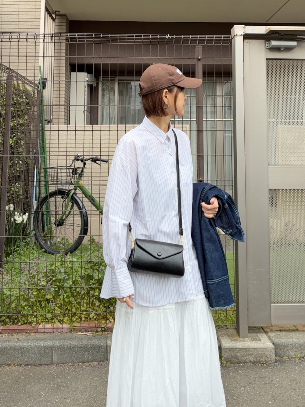 ホワイト系のスカート、ブルー系のデニムジャケット、ホワイト系のシャツ/ブラウスを着用したレディースの春コーディネートの3枚目の写真