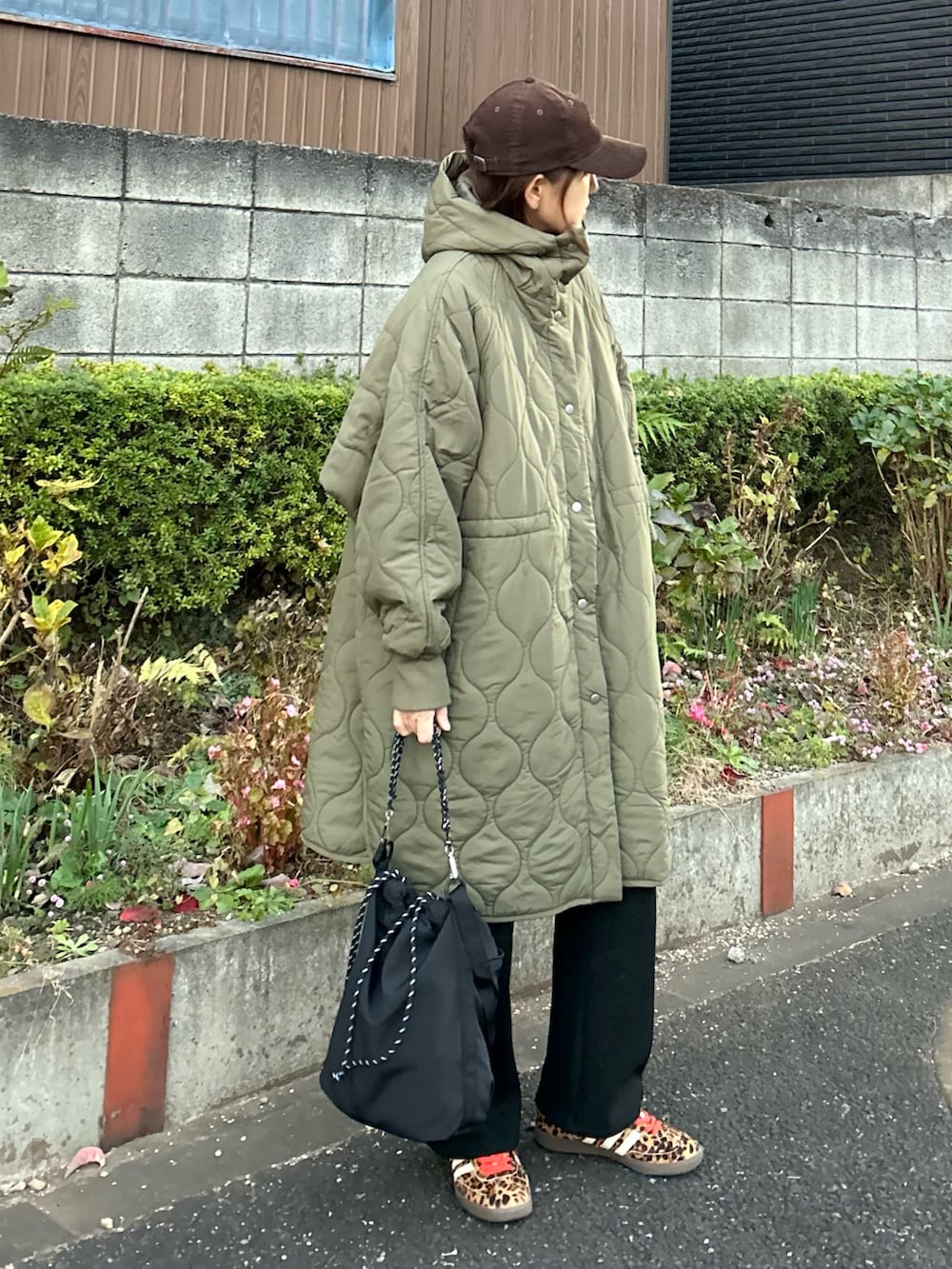 グレー系のニット/セーター、グリーン系のその他アウター、ブラック系のその他パンツを着用したレディースの冬コーディネートの4枚目の写真