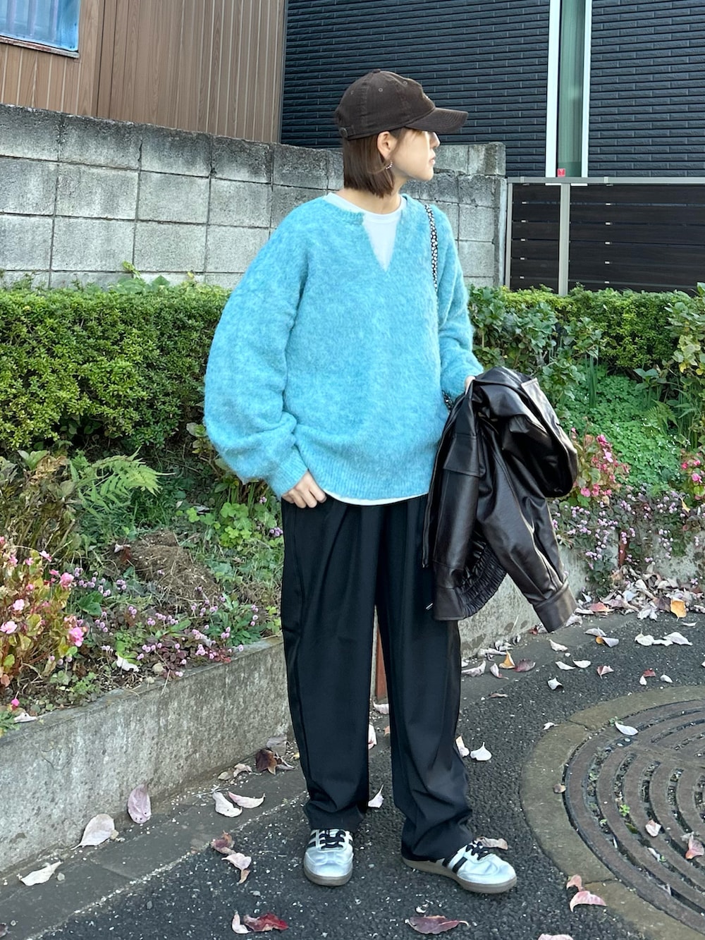 ブルー系のニット/セーター、ブラウン系のブルゾン、ブラック系のその他パンツを着用したレディースの秋コーディネートの2枚目の写真