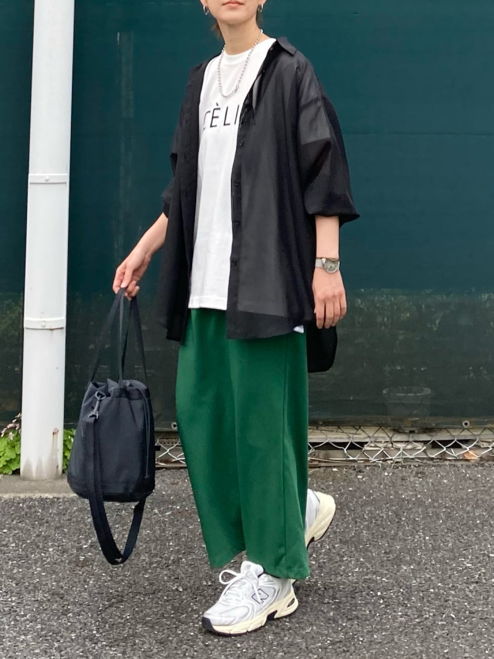 ブラック系のシャツ/ブラウス、グリーン系のスカート、ブラック系のバッグを着用したレディースの春コーディネートの3枚目の写真