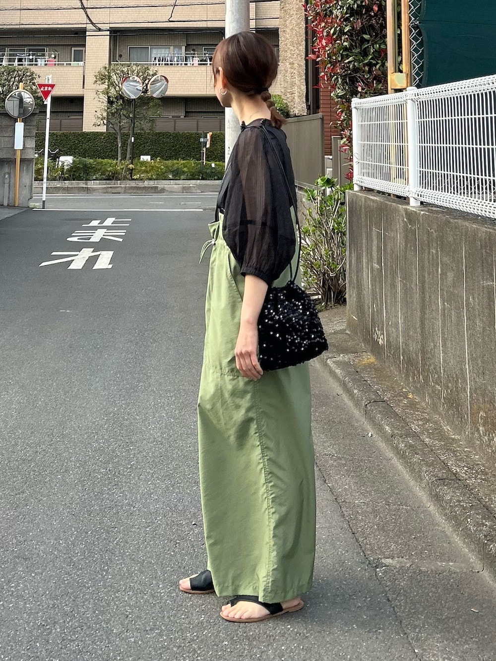 グリーン系のジャンパースカート、ブラック系のシャツ/ブラウス、ブラック系のショルダーバッグを着用したレディースの春コーディネートの5枚目の写真