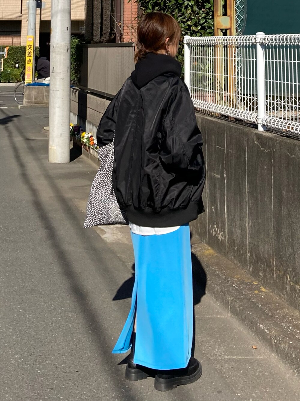 ブラック系のブルゾン、ブラック系のパーカー、ブルー系のスカートを着用したレディースの冬コーディネートの5枚目の写真