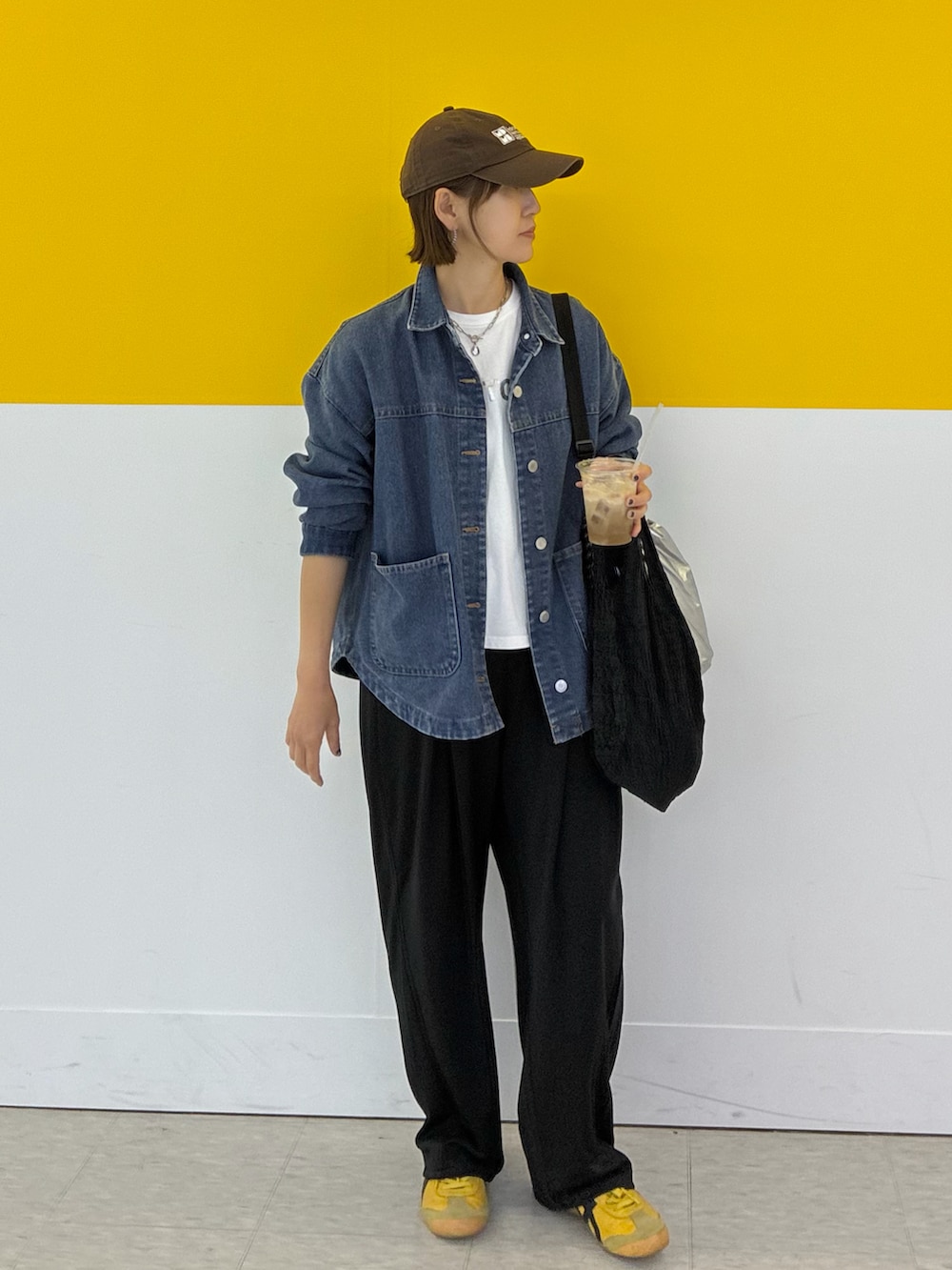 ブラック系のスラックス、ブルー系のデニムジャケット、ホワイト系のTシャツ/カットソーを着用したレディースの春コーディネートの3枚目の写真
