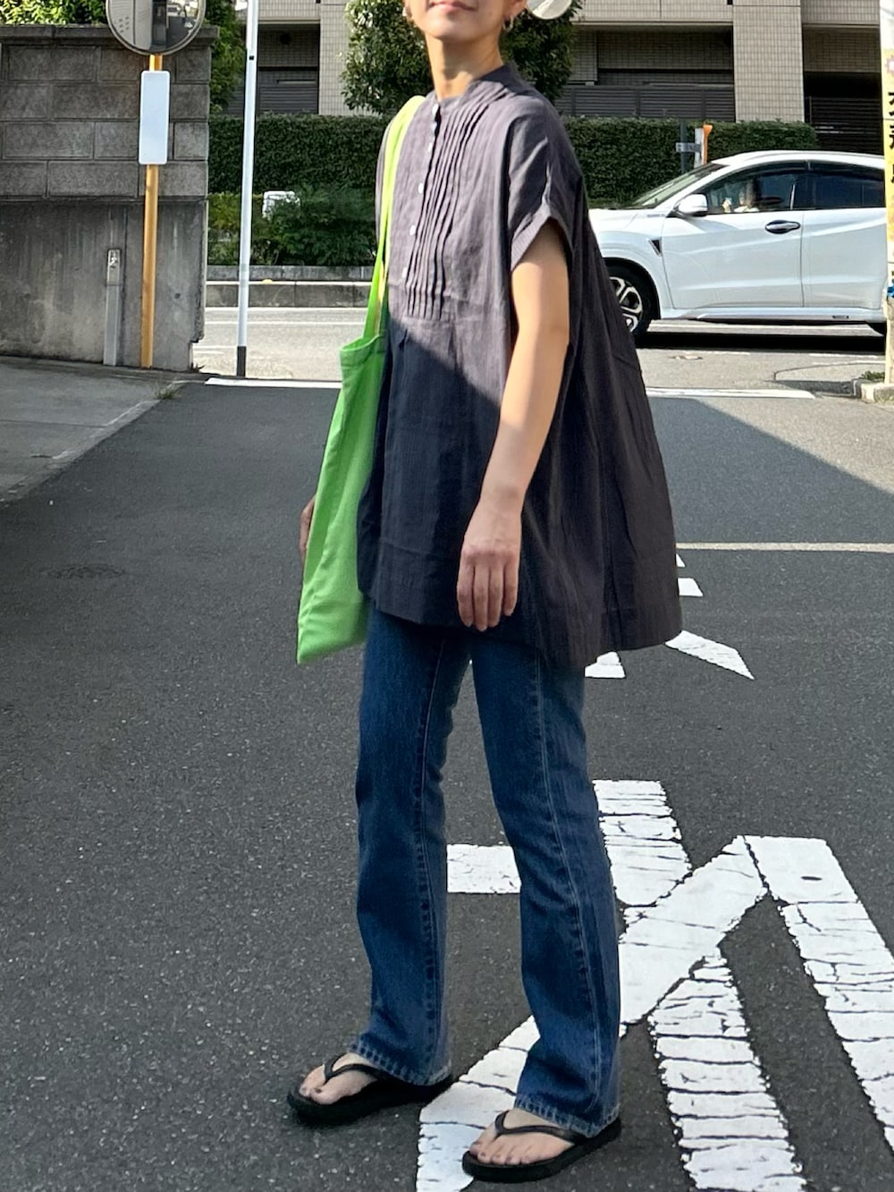 ブルー系のデニムパンツ、グレー系のシャツ/ブラウス、グリーン系のトートバッグを着用したレディースの夏コーディネートの5枚目の写真