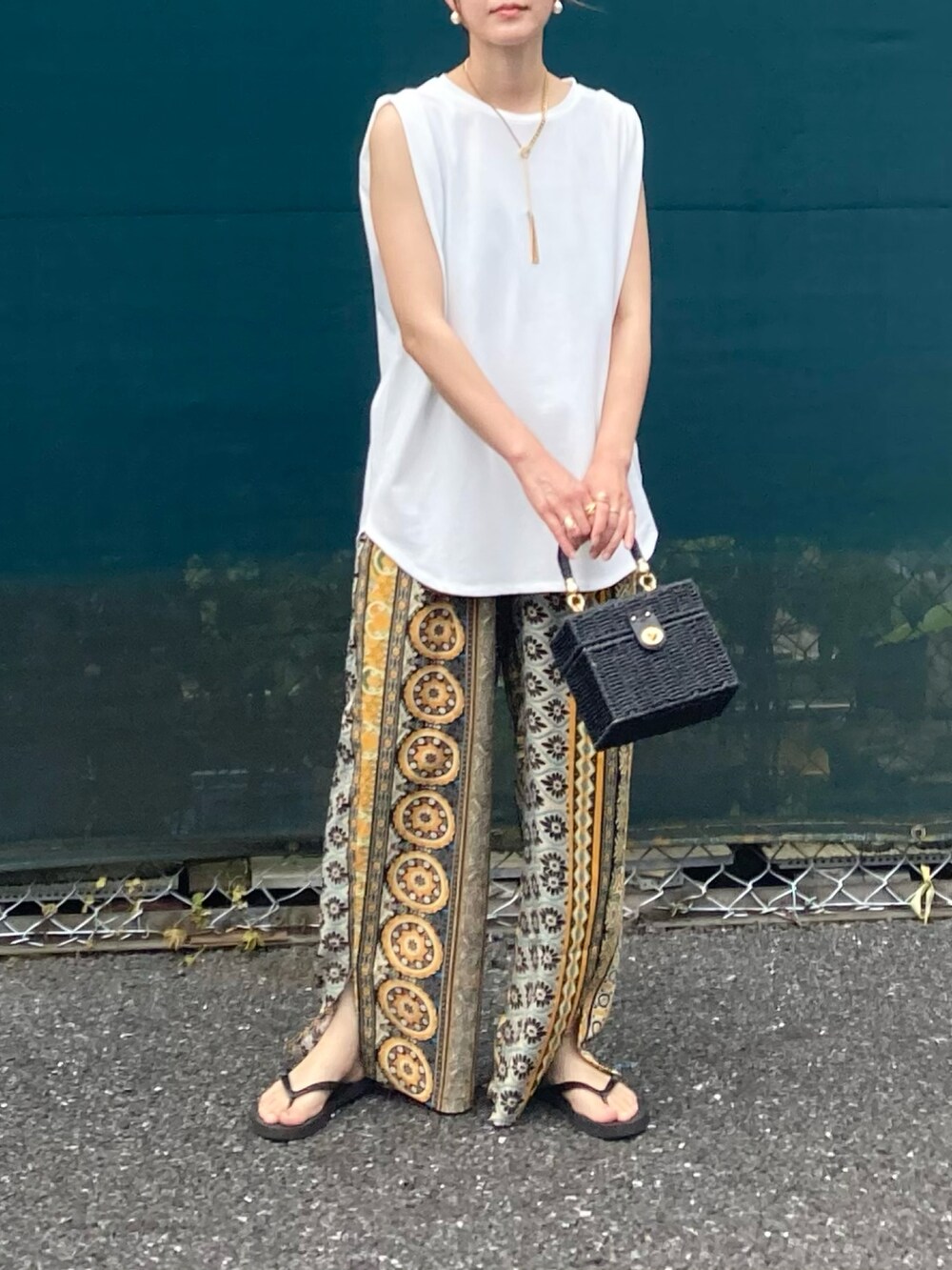 ホワイト系のタンクトップ、イエロー系のその他パンツ、ブラック系のかごバッグを着用したレディースの夏コーディネートの3枚目の写真