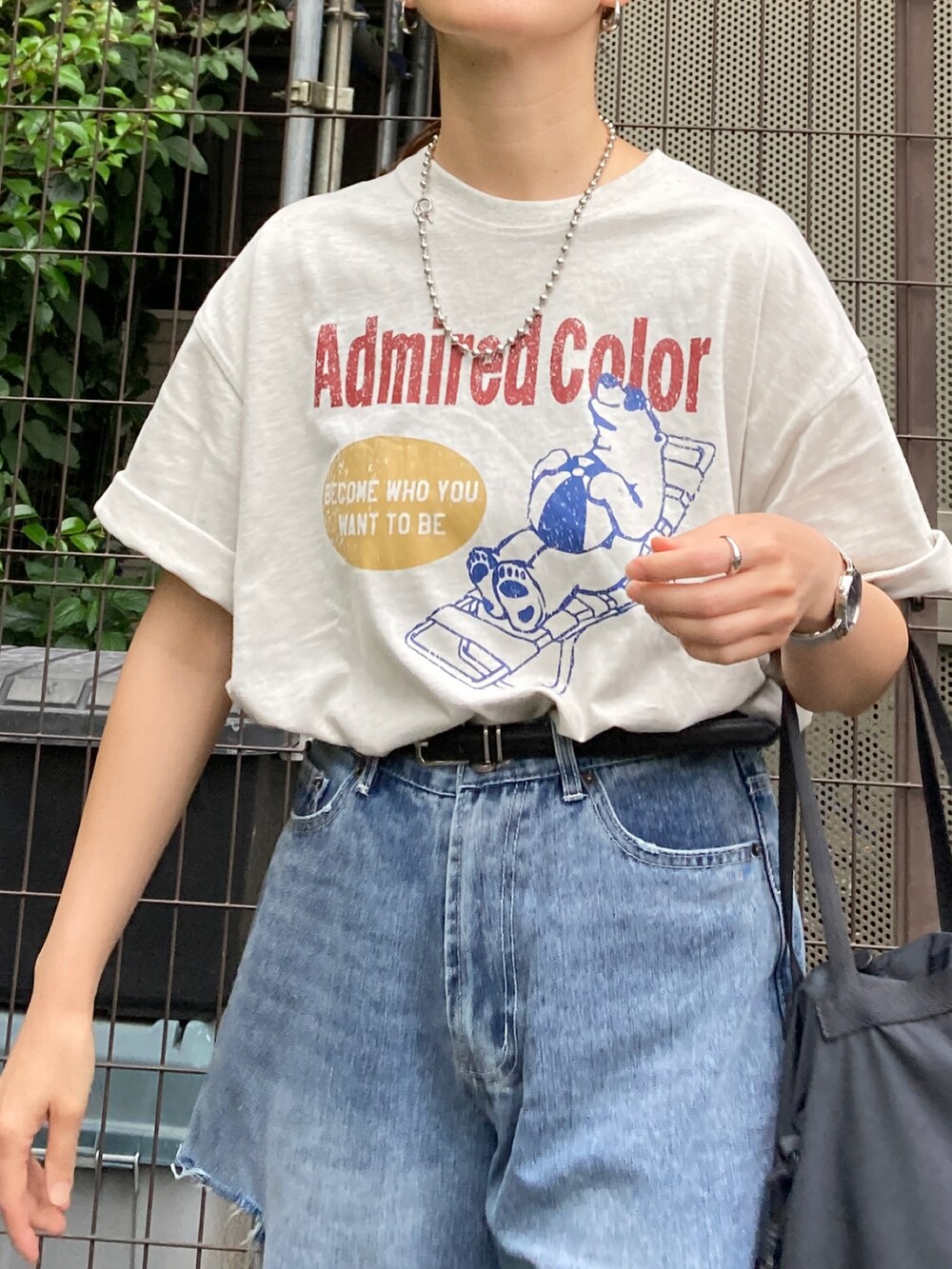 ベージュ系のTシャツ/カットソー、ブルー系のデニムパンツ、ブラック系のバッグを着用したレディースの夏コーディネートの5枚目の写真